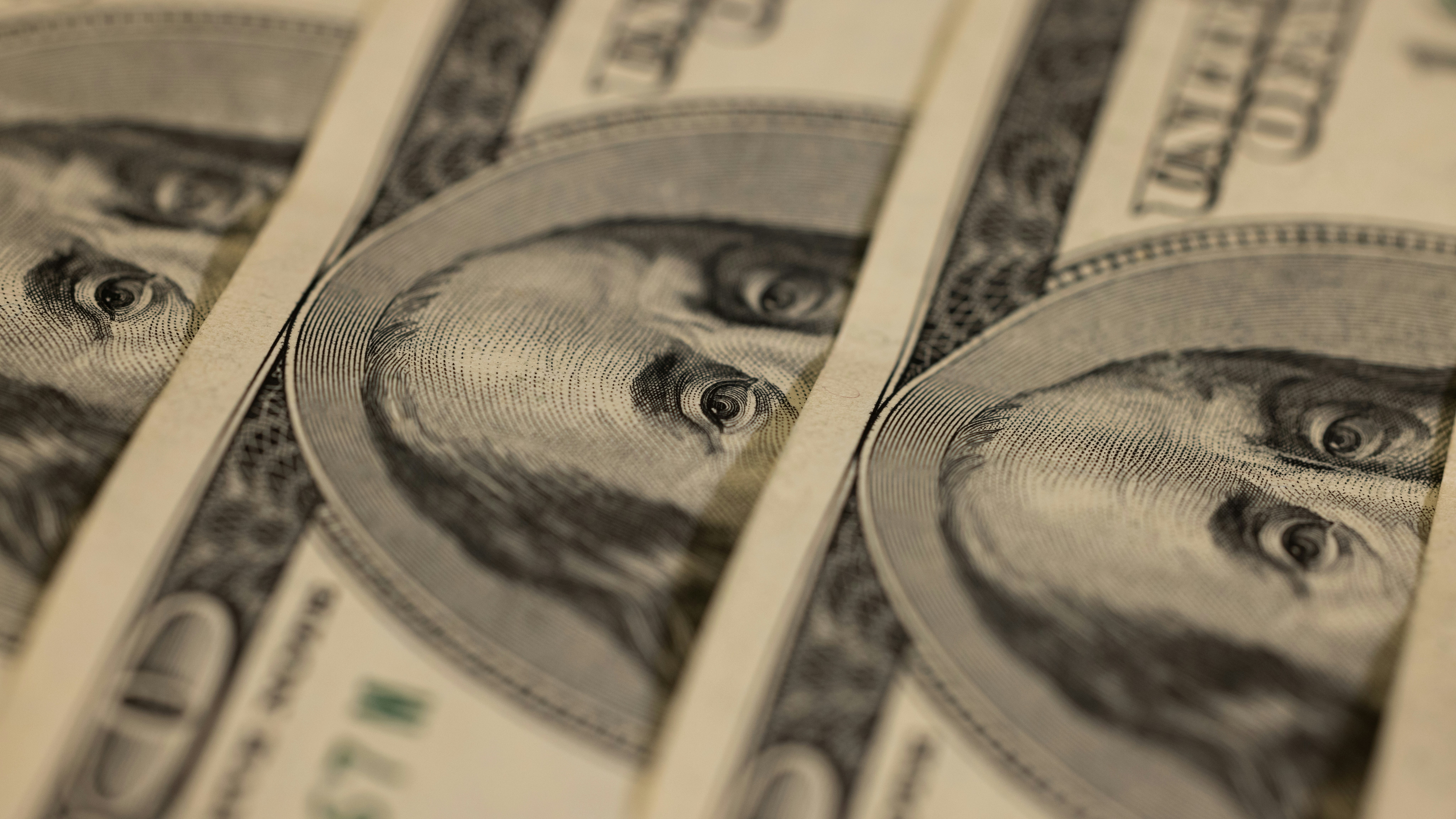 Close-up view of U.S. hundred dollar bills highlighting Benjamin Franklin's eyes, symbolizing the scrutiny of the April U.S. CPI data by forex traders.