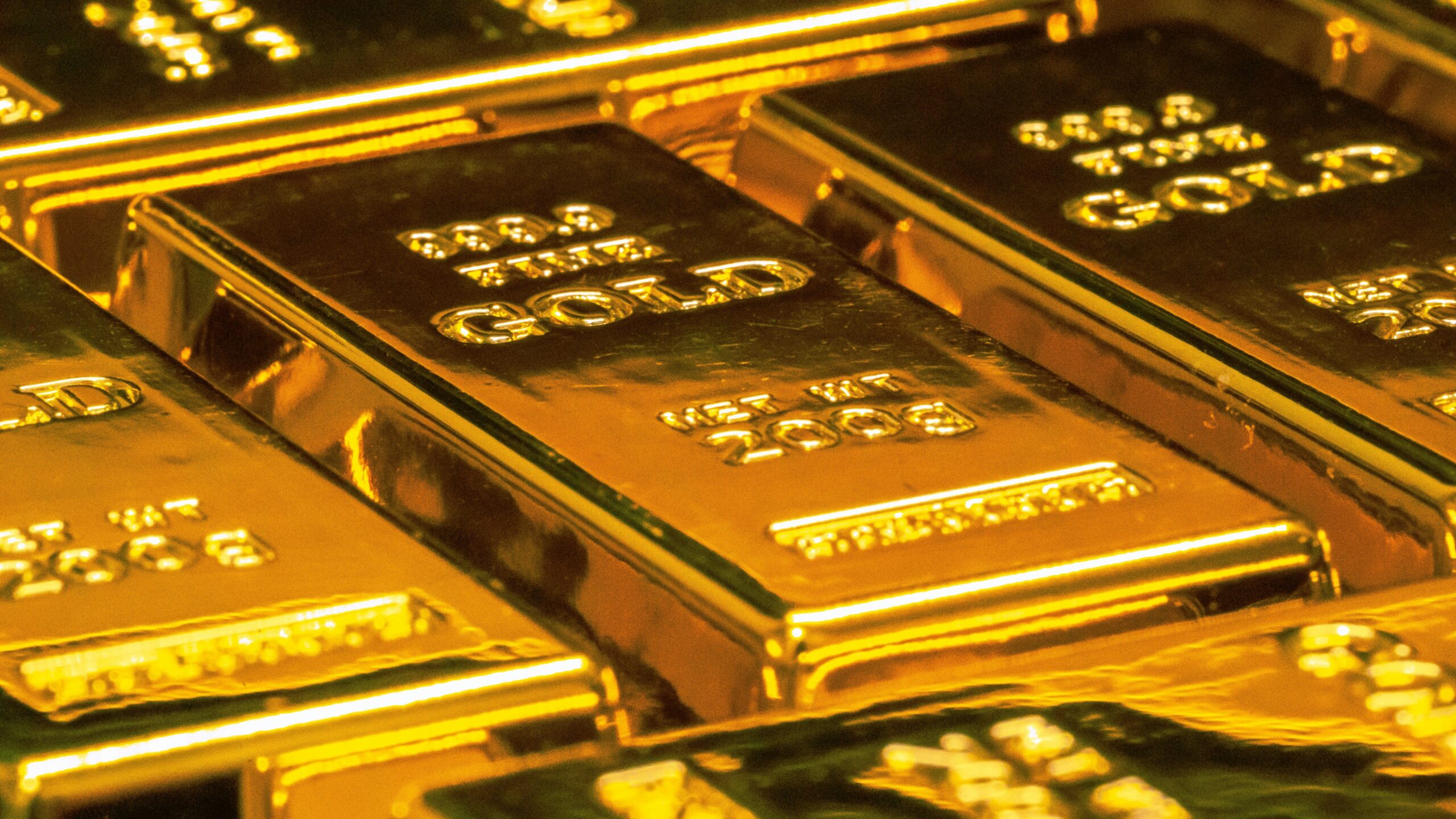 Bars of gold stacked neatly, glistening in light